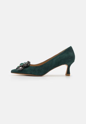 Chaussure escarpin en daim vert foncé avec bout pointu et ornement floral décoratif en perles à l'avant.