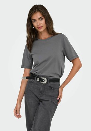 Camisa de manga corta gris de algodón, combinada con unos jeans de mezclilla gris oscuro y un cinturón negro con una hebilla decorativa plateada.