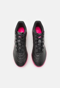 Scarpe da ginnastica nere con superficie texturizzata, punta rotonda e suola rosa brillante. Presentano lacci neri e un interno imbottito.