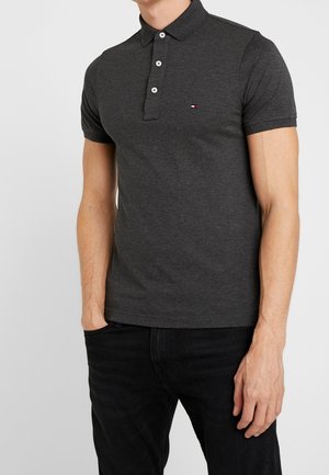 Dark gray polo shirt, cotton material, short sleeves, three-button placket, embroidered logo in red, white, and blue on the left chest.