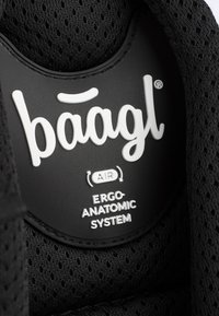 Etichetta di prodotto ergonomico nera che presenta il marchio "baagl," con testo bianco che legge "AIR" e "SISTEMA ERGO-ANATOMICO" su uno sfondo testurizzato.