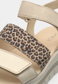 Σανδάλια με μπεζ σουέντ επάνω μέρος, λουρί με λεοπάρ σχέδιο από ύφασμα και χοντρή πλατφόρμα με υφή λεπτομέρειες.