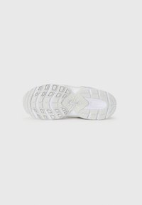 Semelle de chaussure de sport blanche avec caoutchouc texturé, motif de bande de roulement rectangulaire et logo Nike. Comprend un design d'amortissement pour une traction et un soutien.