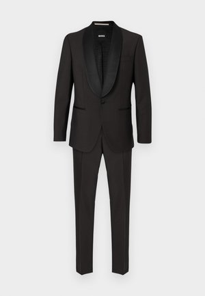 Zwarte smoking met een satijnen sjaalkraag, enkele knoopsluiting en twee voorzakken. Gladde stof met een getailleerde pasvorm en persvouwen.