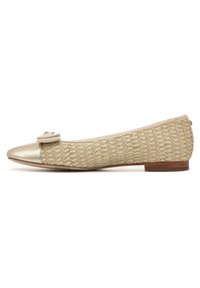 Scarpa piatta con punta dorata metallica e corpo tessuto strutturato di colore beige chiaro. Presenta un piccolo fiocco decorativo sulla punta. Tacco piatto di colore marrone.