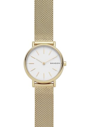 Montre Skagen ton or avec cadran blanc, index et aiguilles dorés minimalistes, et bracelet en maille dorée.