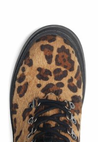 Stivaletti alla caviglia in pelle di leopardo con texture in morbido topo marrone, lacci neri e occhielli metallici. Suola nera resistente per un'ottima trazione.
