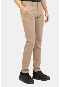 Chino beige realizzati in un mix di cotone, con una vestibilità slim, tasche laterali e chiusura con zip. Abbinati a sneakers nere.