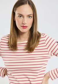 Camicia a maniche lunghe a righe in crema e rosa. Presenta un collo tondo e una vestibilità rilassata. Tessuto morbido con maniche a contrasto.