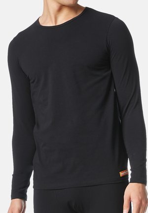 Zwarte langemouwen shirt van zacht katoen. Heeft een ronde hals, een verstelbare pasvorm en een klein oranje label aan de zoom.