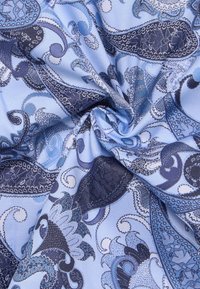 Lichtblauwe stof met een paisleypatroon in marineblauw en donkerdere tinten blauw. De textuur is glad met ingewikkelde details in het ontwerp.