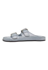 Blaue Denim-Sandale zum Hineinschlüpfen mit zwei verstellbaren Schnallen, flacher Sohle und strukturierter Oberseite. Offenes Design mit Ausschnitten für Atmungsaktivität.