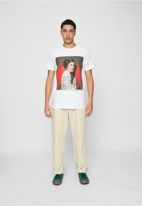 Weißes Baumwoll-T-Shirt mit einem grafischen Druck eines Charakters mit dunklen Haaren und einer hellen Kleidung vor einem roten Hintergrund, gebrandet mit "Star Wars."