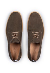 Zapatos de ante marrón con cordones y punta redondeada, suela de goma marrón clara e interior de cuero. Detalle de costura destacado en los laterales.