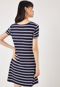 Navyblau-weiß gestreiftes Kurzarmkleid mit Rundhalsausschnitt, bequemer Passform und seitlichen Schlitzen für Bewegungsfreiheit.