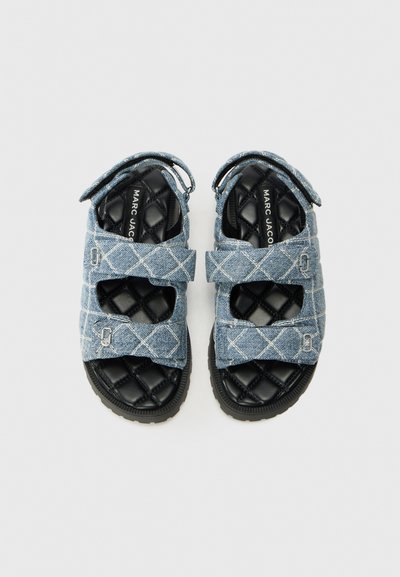 Denim sandalen met doorgestikte zwarte binnenzolen en verstelbare banden, voorzien van zilveren accenten en een diamanten patroon op de blauwe bovenkant.