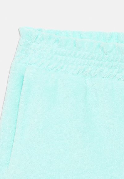 Υφασμα από πετσέτα σε ανοιχτό γαλάζιο χρώμα με φαρδιά ζώνη μέσης που διαθέτει ελαστικές πιέτες, πιθανότατα μέρος ενός ενδύματος ή πετσέτας.