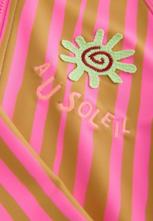 Badebekleidung mit kräftigen pinken und braunen Streifen, einem grünen Sonnenmotiv in Stickerei und dem Text "AU SOLEIL" in pinkem Garn. Weiche Textur.