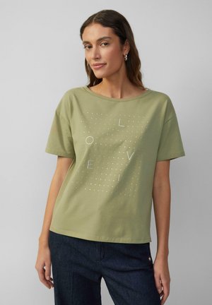 Olijfgroene katoenen T-shirt met korte mouwen, ronde halslijn en een "LOVE" grafisch ontwerp in witte stippen en letters.
