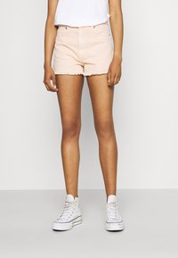 Vaaleanpunaiset farkkushortsit, joissa on risatut reunat, klassinen viisi taskua -muotoilu. Asusteena valkoiset korkeavyötäröiset tennarit ja yksinkertainen valkoinen t-paita.