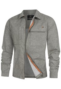 Chemise gris clair à manches longues avec col, fermeture éclair avant partiellement ouverte, deux poches poitrine et détail orange le long de la doublure de la fermeture éclair.