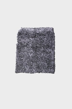 Tappeto grigio shaggy con superficie testurizzata, caratterizzato da un design soffice. I bordi sono irregolari, migliorando l'aspetto morbido e accogliente.