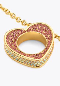 Pendentif en forme de cœur en or, orné de pierres précieuses roses et iridescentes, avec des montures délicates et un centre creux, relié par une chaîne en or.