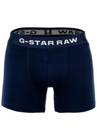 Boxers azul marino hechos de una tela elástica con una cinturilla elástica que presenta el logo "G-STAR RAW". Las costuras dobles proporcionan durabilidad.
