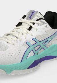Άσπρο και ανοιχτό γκρι αθλητικό παπούτσι Asics με τυρκουάζ και μωβ ακτίνες στη σόλα και λευκά κορδόνια σε απλό φόντο.