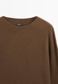 Maglione marrone lavorato a maglia con collo a girocollo a coste, spalle corte e un'etichetta nera con la scritta "Massimo Dutti Made in China."