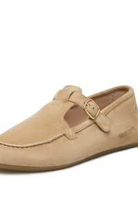 Beige Wildlederschuh zum Hineinschlüpfen mit einem T-Riemen-Design, goldener Schnallen-Akzent und gestickten Details entlang der Kanten. Flache Sohle.
