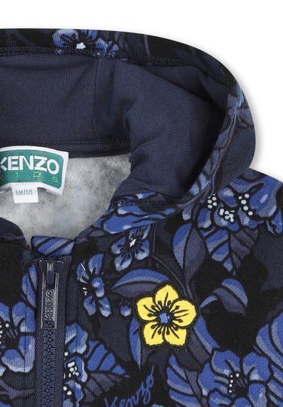 Veste à capuche en marine avec un motif floral. Présente une fleur brodée jaune et une fermeture éclair à l'avant. Doublure intérieure douce pour plus de confort.