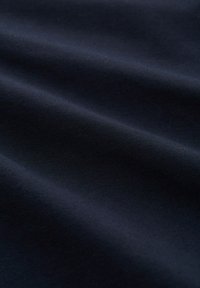Tejido azul marino oscuro con una textura suave, que presenta ondas sutiles y líneas de tensión, mostrando un peso y elasticidad medios.