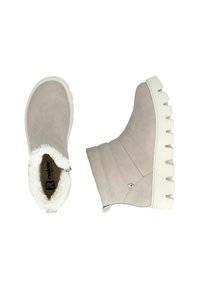 Bottines beiges en suède avec une doublure en fausse fourrure, dotées d'une épaisse semelle en caoutchouc blanc et d'une fermeture éclair sur le côté.