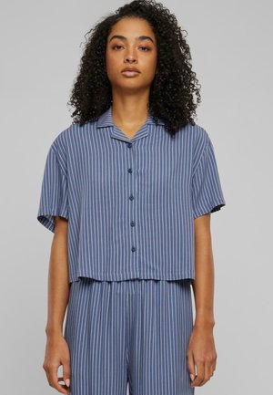 Camicia abbottonata blu con righe verticali bianche, maniche corte e colletto. Il tessuto appare liscio con una leggera texture.