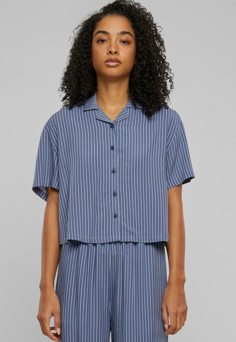 Cropped button-up shirt in blue with vertical white stripes, short sleeves, and a collar. Fabric appears smooth with a light texture.
