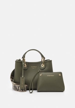 Groene leren handtas en bijpassend kleiner tasje met gouden hardware en een stoffen band met bedrukte tekst.