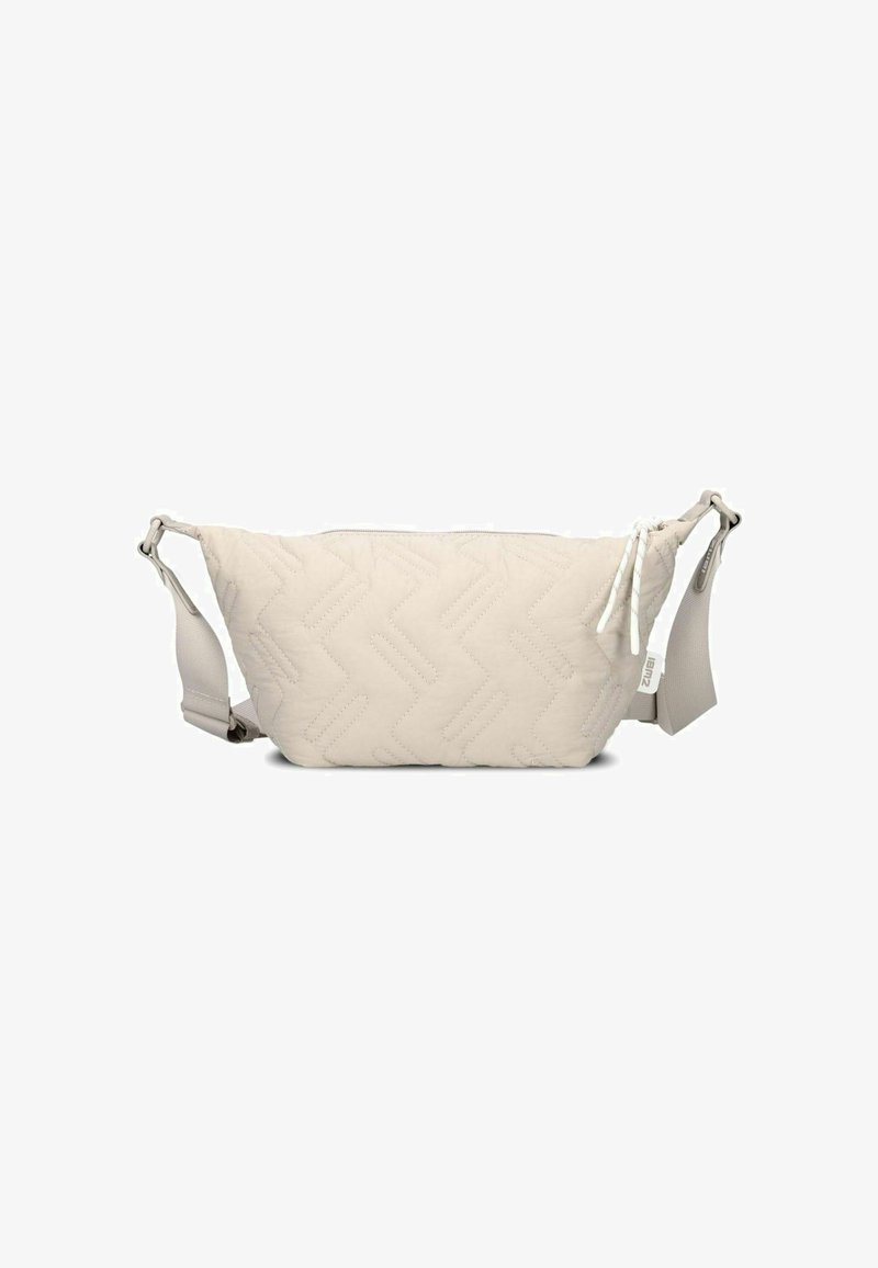 Gequilte beige heuptas met zigzagpatroon, voorzien van een ritsluiting en een verstelbare schouderband, gemaakt van zacht stof.