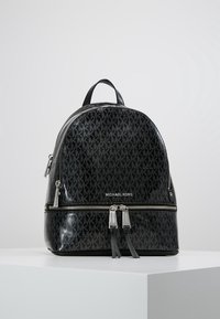 Zaino in ecopelle nera con motivo a monogramma, forma rotonda, chiusura a doppia zip e manico superiore per il trasporto.