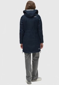 Navy long jacket with a hood, featuring a cinched waist, side pockets, and a logo detail on the upper back. Soft, textured fabric.