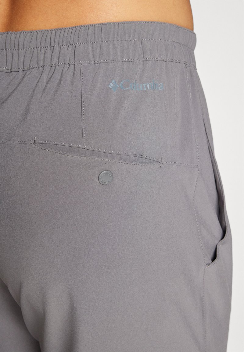 Graue Shorts mit elastischem Bund, ausgestattet mit einer Gesäßtasche und dezenten Logodetails. Hergestellt aus leichtem, glattem Stoff.