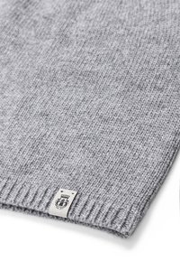 Gray knitted scarf made from soft material, featuring a ribbed edge and a small label with a logo on one side.