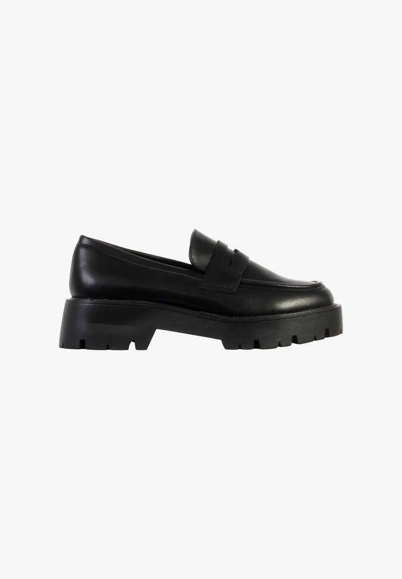Mocassin en cuir noir à semelle épaisse, talon relevé et semelle extérieure rainurée, style slip-on avec détail de bride sur le dessus.