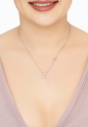 Silver necklace with a Pisces symbol, adorned with small gemstones. Chain is delicate and minimalistic, complementing the neckline.