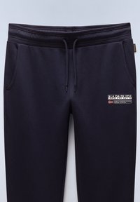 Marineblauwe trainingsbroek met een drawstring tailleband, twee zijzakken en een logo-label met tekst en een vlagmerk op de linker bovenbeen.