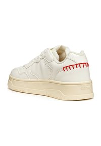 Sneaker bianca in pelle con finitura texture, suola in gomma color crema e dettagli cuciti rossi sul tallone. Nome del marchio "GEOX" impresso di lato.