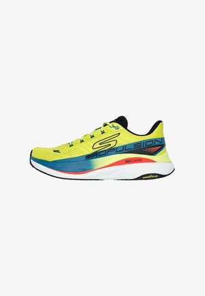 Zapatos de correr con una parte superior de malla amarilla brillante, acentos azules y una suela blanca con detalles en rojo y negro. Incluye etiqueta "MAX CUSHION".