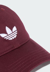 Maroon kapica za bejzbol od pamuka s zakrivljenim vizirima. Sadrži bijeli Adidas trefoil logo i ukrasne šavove na viziru.
