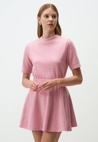 Abito rosa a maniche corte con colletto alto e gonna a ruota. Realizzato in tessuto morbido, con una texture liscia e un design semplice.