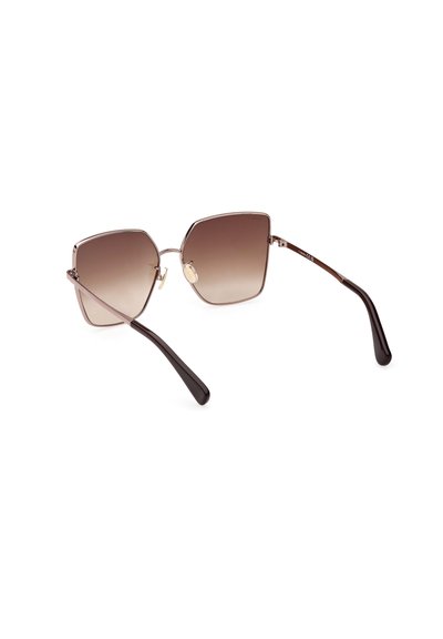 Gafas de sol con degradado marrón en forma hexagonal geométrica, montura de metal y brazos de acetato negro. Presentan almohadillas en la nariz para mayor comodidad.